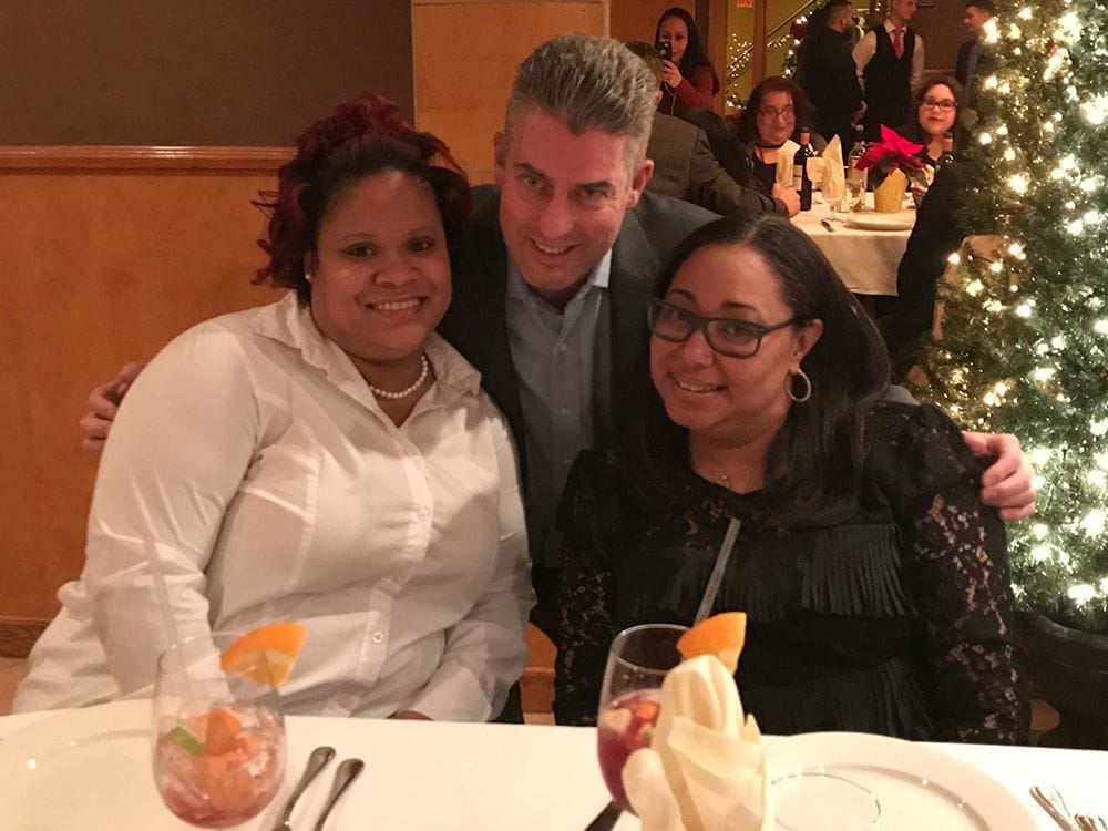 Dr. Weiss posing with staff at table